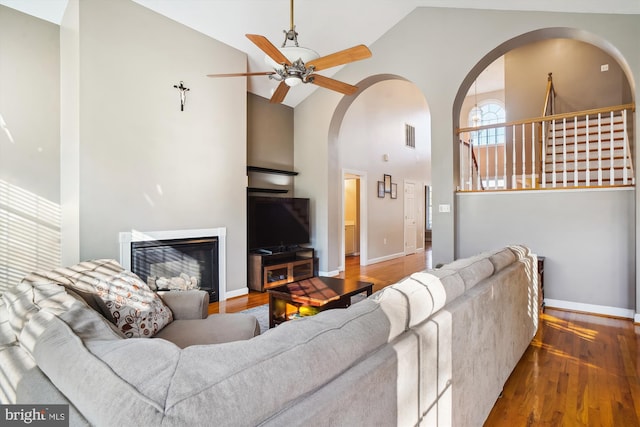 living room featuring ceiling fan, high vaulted ceiling, and hardwood / wood-style flooring