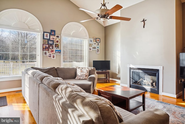 living room featuring high vaulted ceiling, light hardwood / wood-style floors, and ceiling fan