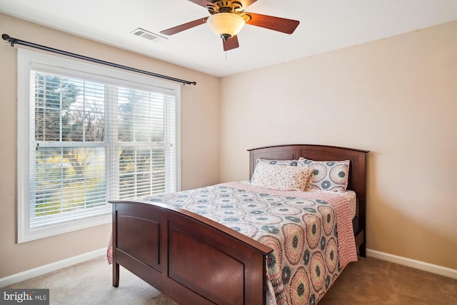 bedroom with light carpet, ceiling fan, and multiple windows