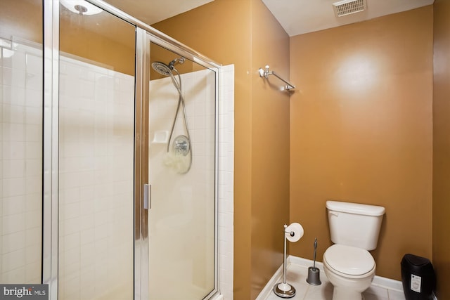 bathroom featuring toilet, a shower with shower door, and tile flooring