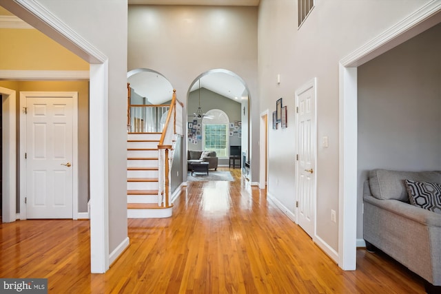 corridor featuring a notable chandelier, high vaulted ceiling, and light hardwood / wood-style floors