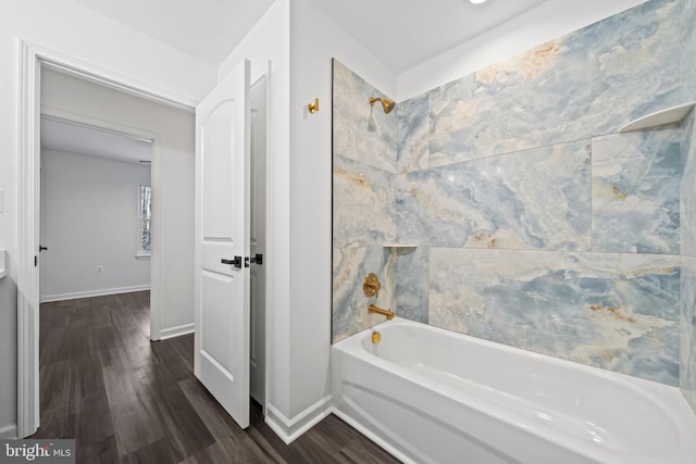 bathroom featuring wood-type flooring and tiled shower / bath