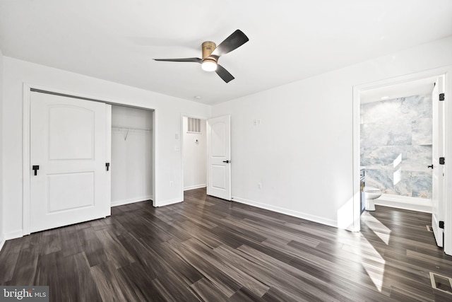 unfurnished bedroom with a closet, dark hardwood / wood-style floors, ceiling fan, and ensuite bathroom