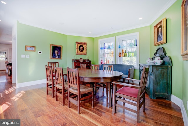 dining space with light hardwood / wood-style flooring, a wealth of natural light, and ornamental molding