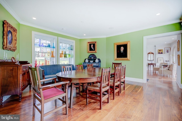 dining room featuring light hardwood / wood-style flooring and crown molding