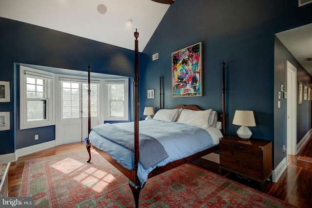 bedroom with high vaulted ceiling and dark hardwood / wood-style floors