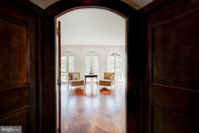 hallway featuring ornamental molding and light parquet flooring