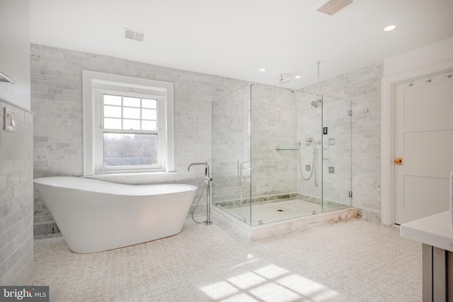 bathroom with tile walls, plus walk in shower, and tile floors