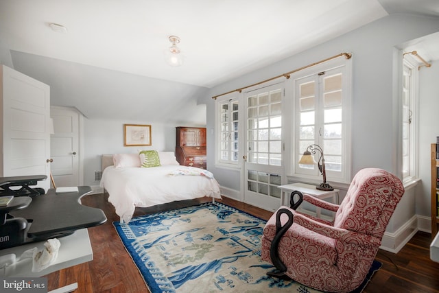 bedroom with dark wood-type flooring, vaulted ceiling, and french doors