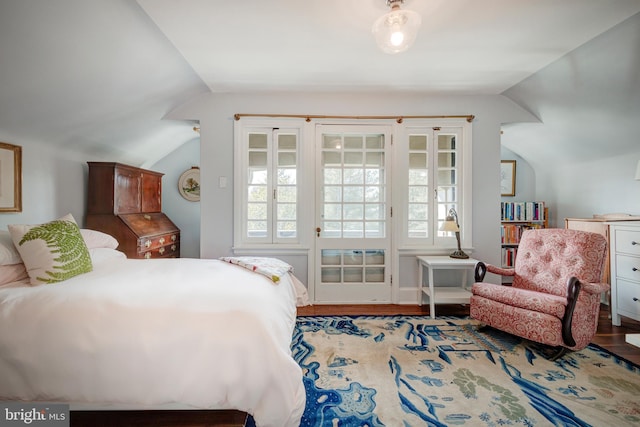 bedroom with lofted ceiling, light hardwood / wood-style floors, and multiple windows