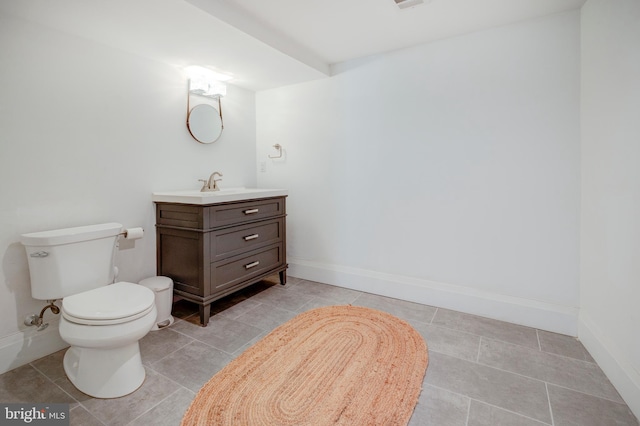 bathroom with toilet, vanity, and tile flooring