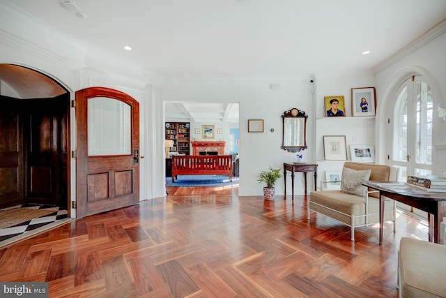 sitting room with dark parquet flooring and crown molding