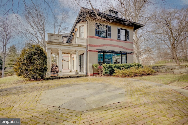 view of front facade with a balcony and a patio area