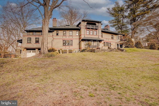 back of house featuring a garage and a yard