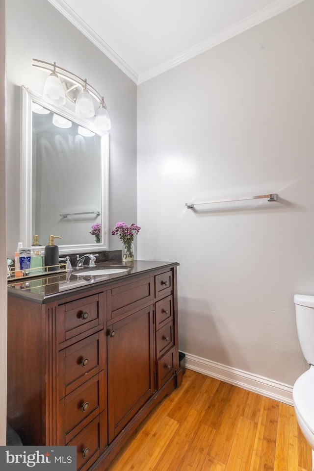 bathroom with vanity, hardwood / wood-style floors, toilet, and ornamental molding