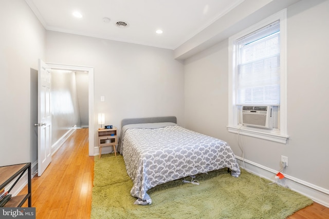 bedroom featuring crown molding and light wood-type flooring