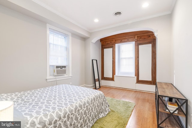 bedroom featuring light wood-type flooring and ornamental molding