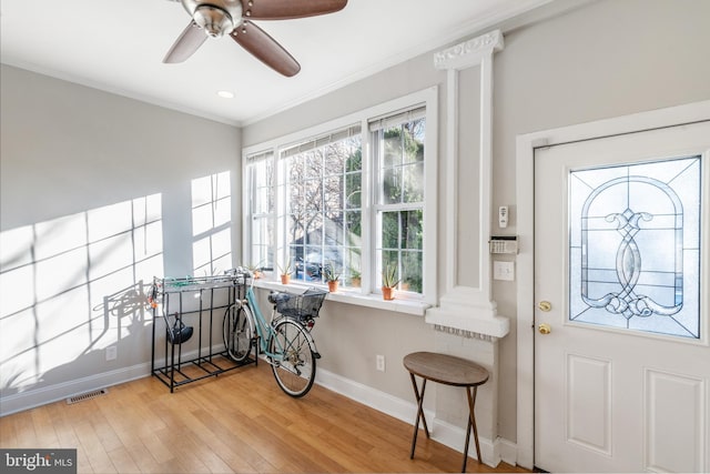 entrance foyer with ornate columns, crown molding, light hardwood / wood-style floors, and ceiling fan