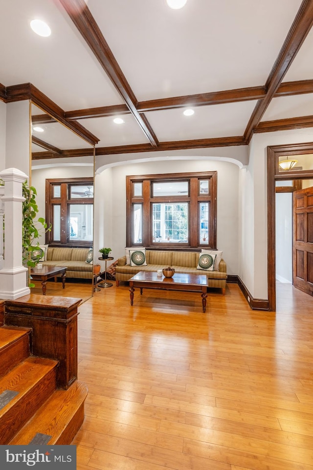 living room with ornate columns, coffered ceiling, and light wood-type flooring