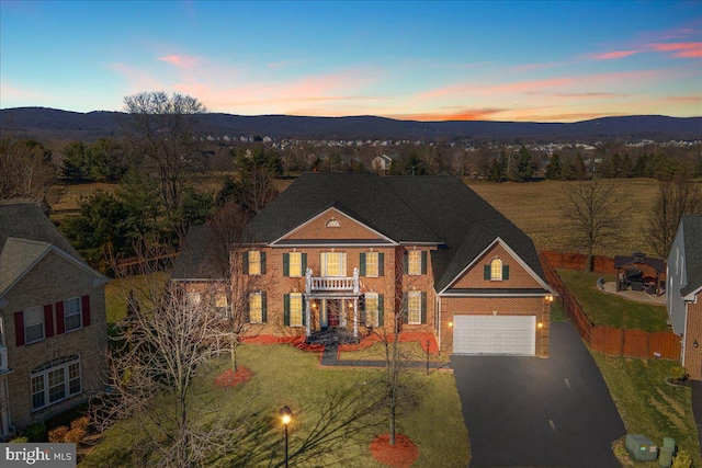 view of front of property featuring a lawn, a mountain view, and a garage