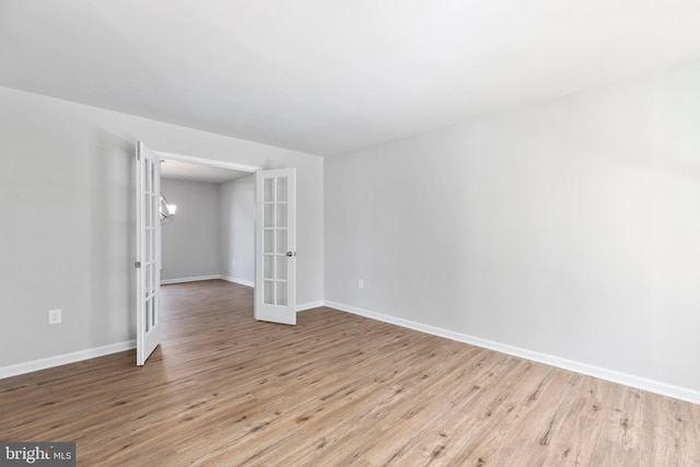 empty room featuring light wood-type flooring and french doors