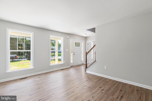 unfurnished room featuring plenty of natural light and dark wood-type flooring