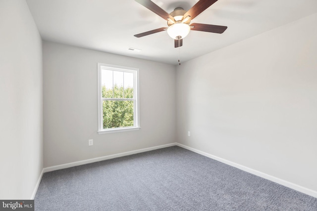 spare room with dark colored carpet and ceiling fan