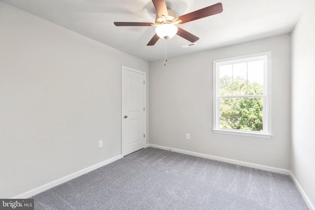 carpeted spare room featuring ceiling fan