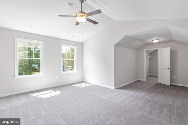 bonus room featuring ceiling fan, dark colored carpet, and vaulted ceiling