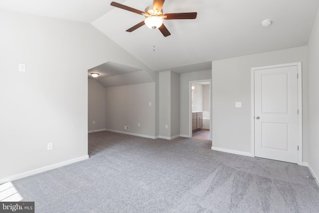 unfurnished room with light carpet, ceiling fan, and vaulted ceiling