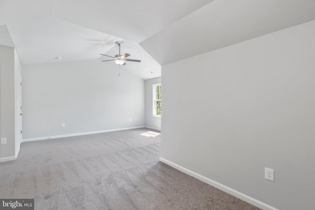 unfurnished room with ceiling fan, light colored carpet, and vaulted ceiling