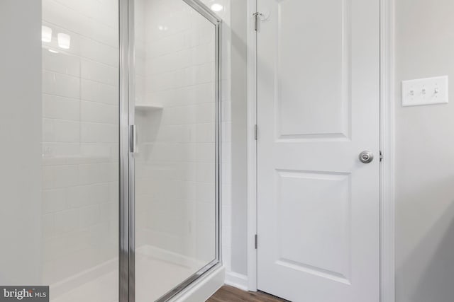 bathroom featuring a shower with door and hardwood / wood-style floors