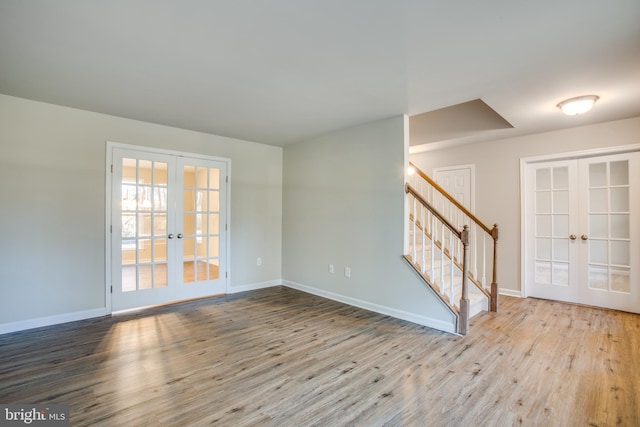 unfurnished room featuring french doors and light hardwood / wood-style flooring