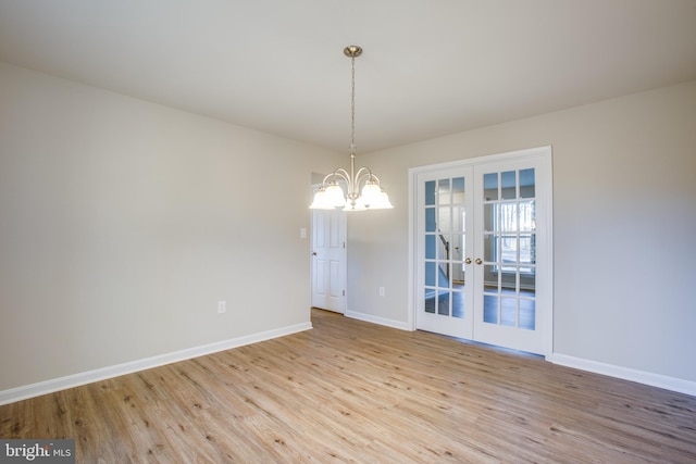 unfurnished room with french doors, a chandelier, and light hardwood / wood-style floors