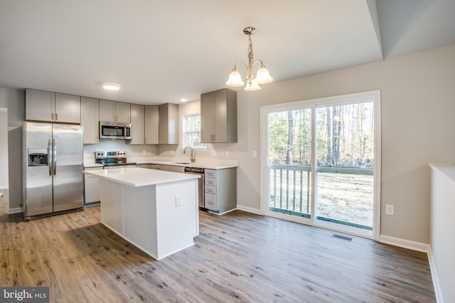 kitchen featuring gray cabinetry, appliances with stainless steel finishes, and light hardwood / wood-style flooring