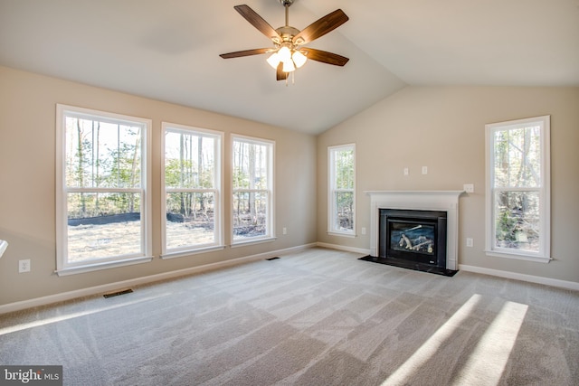 unfurnished living room featuring lofted ceiling, ceiling fan, and light carpet