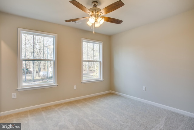 spare room with ceiling fan and light carpet