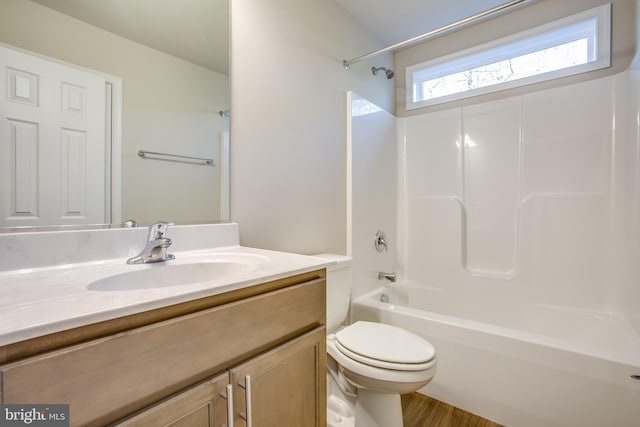 full bathroom featuring toilet, shower / bathtub combination, hardwood / wood-style floors, and vanity with extensive cabinet space