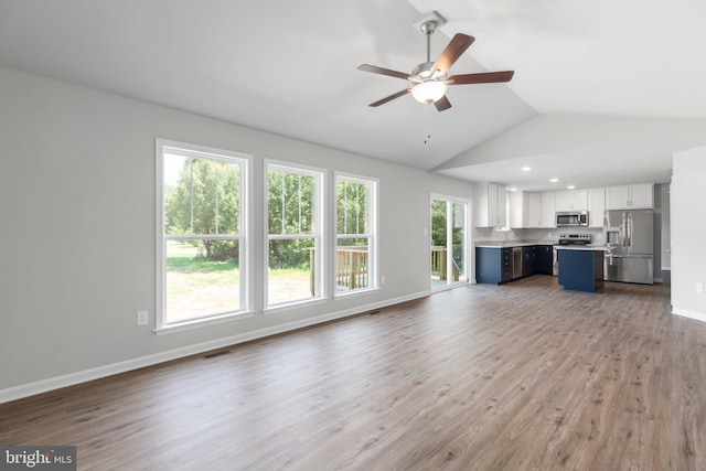 unfurnished living room featuring vaulted ceiling, ceiling fan, and hardwood / wood-style flooring