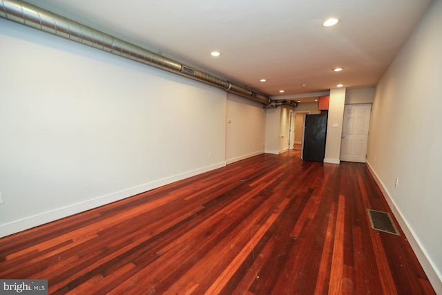 basement with dark hardwood / wood-style floors