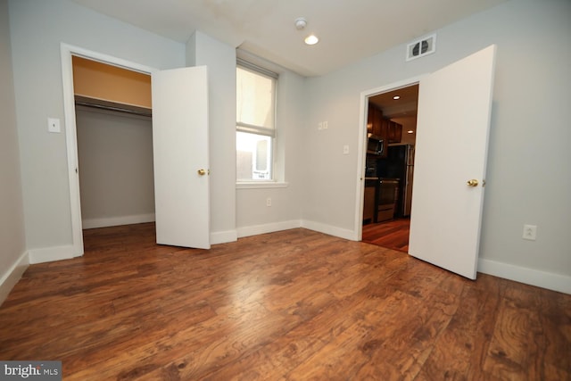 unfurnished bedroom with dark wood-type flooring and a closet