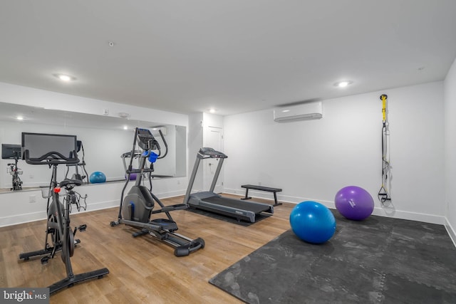 workout area with a wall mounted air conditioner and hardwood / wood-style floors