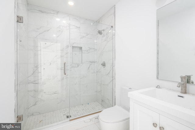 bathroom with vanity, toilet, and a shower with shower door