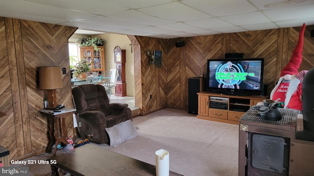 living room featuring wood walls and a paneled ceiling