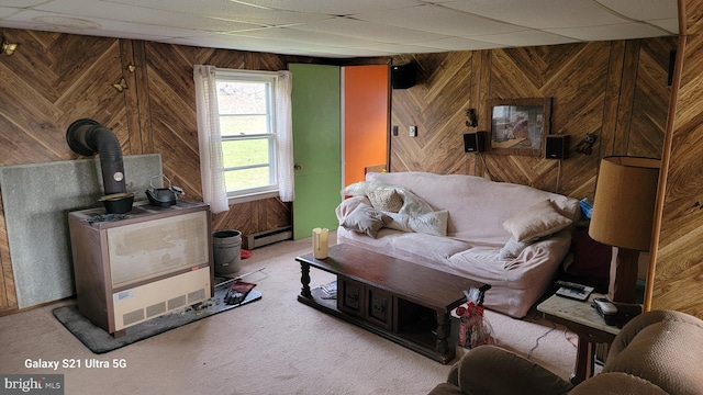 carpeted living room with a baseboard heating unit, a drop ceiling, and wooden walls