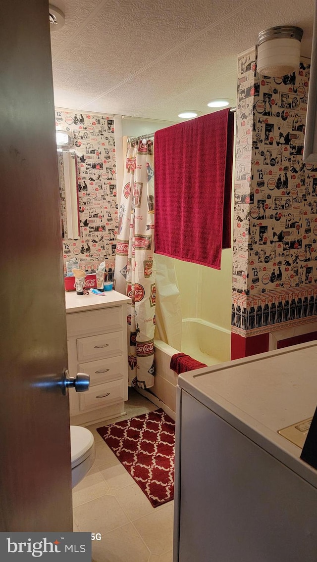 full bathroom featuring toilet, shower / bathtub combination with curtain, a textured ceiling, vanity, and tile floors