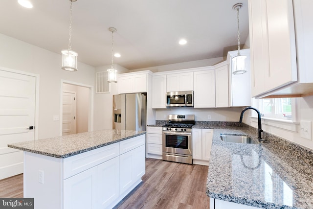 kitchen with light hardwood / wood-style floors, stainless steel appliances, light stone countertops, white cabinetry, and sink