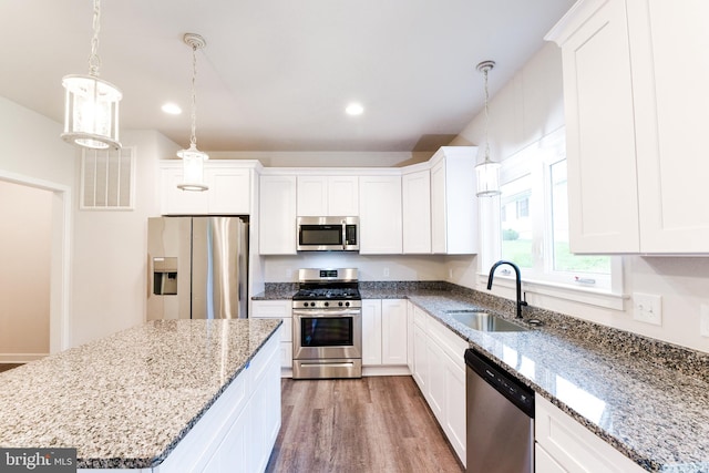 kitchen featuring white cabinets, hardwood / wood-style floors, appliances with stainless steel finishes, and sink