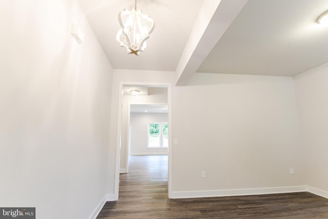 corridor featuring dark hardwood / wood-style flooring and an inviting chandelier