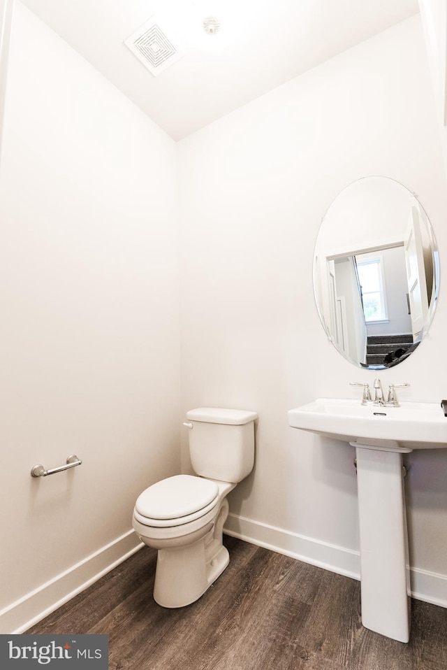 bathroom featuring sink, wood-type flooring, and toilet